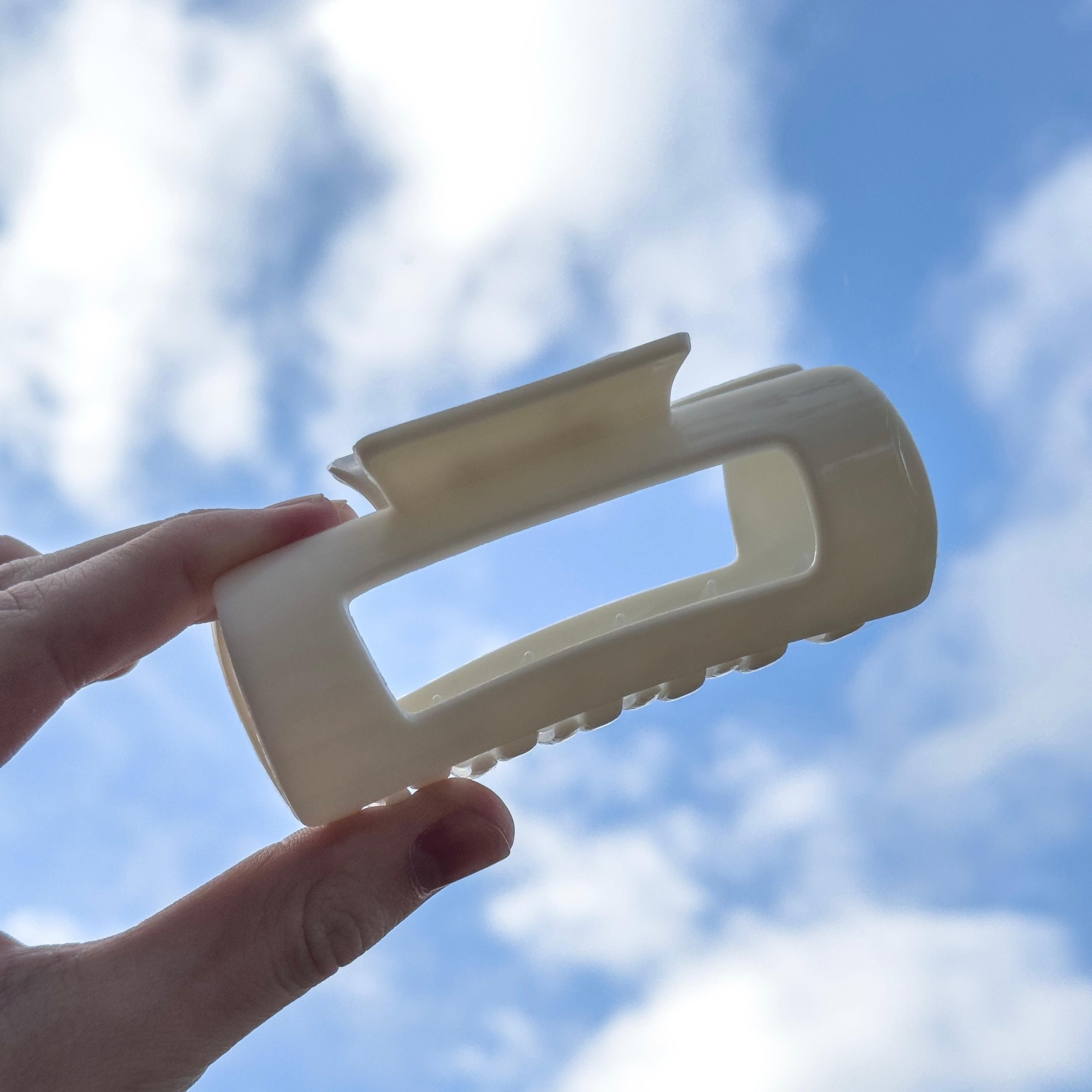 Biała klamra ElastiClip na niebieskim tle